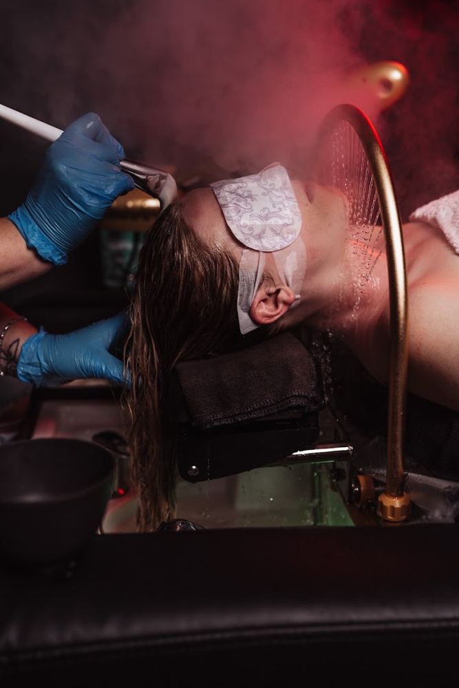 A client relaxing during a head spa treatment with warm water and steam
